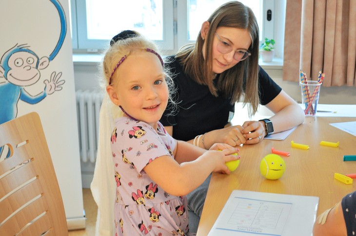 Ein Mädchen bastelt mit Tennisbällen