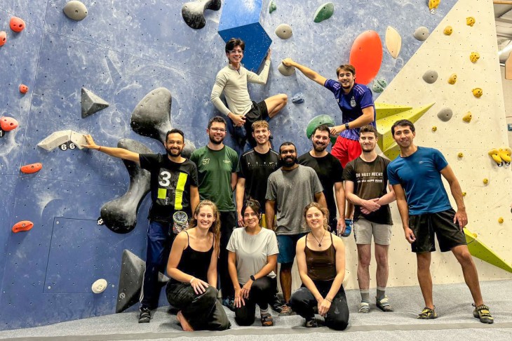 Personen stehen vor einer Kletterwand